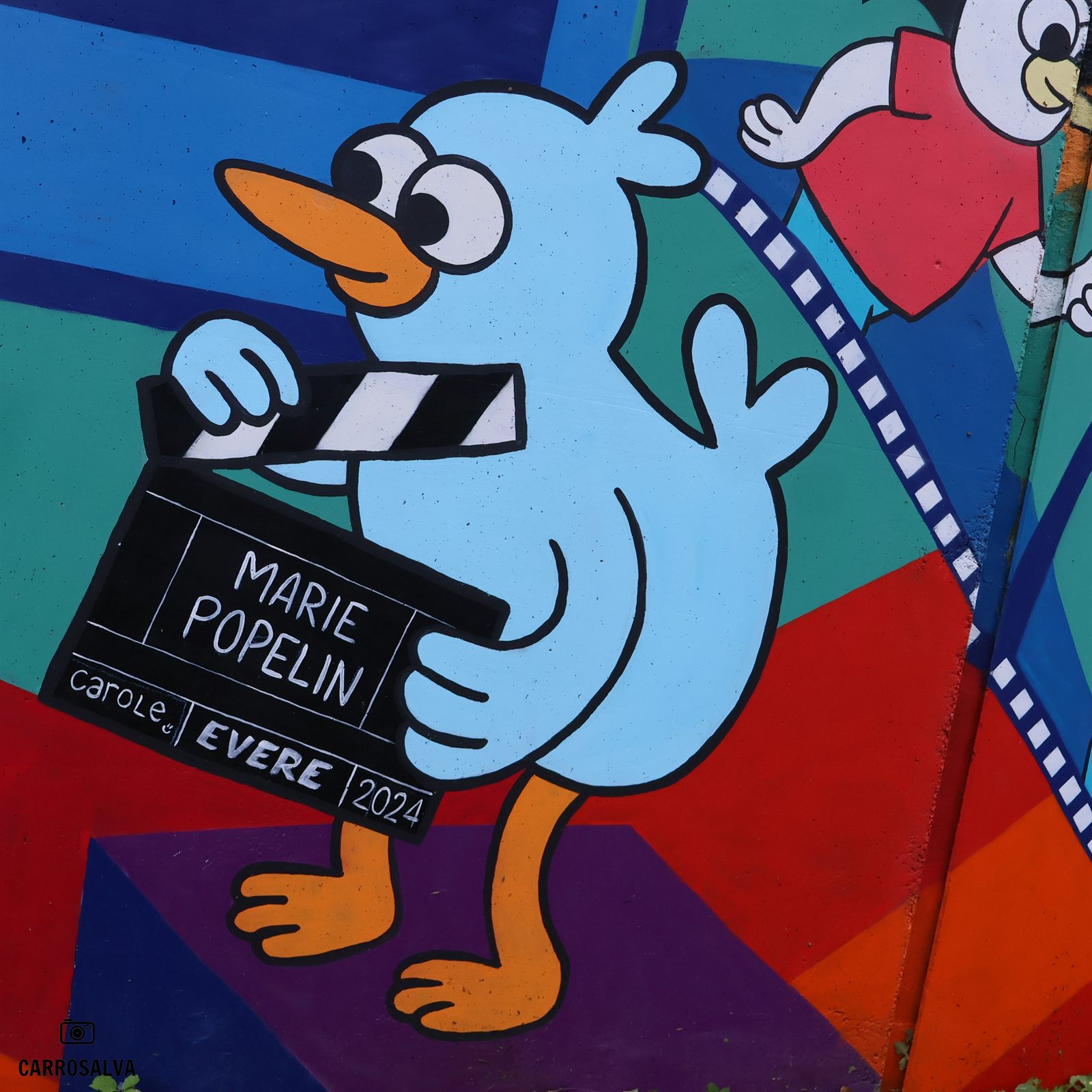 Fresque d’un canard tenant un clap de cinéma « Marie Popelin – Evere 2024 »
