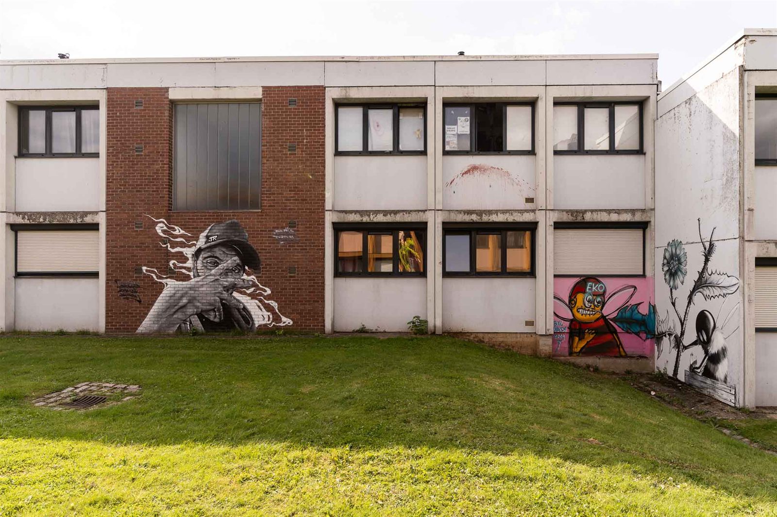Façade d’école couverte de plusieurs fresques du festival